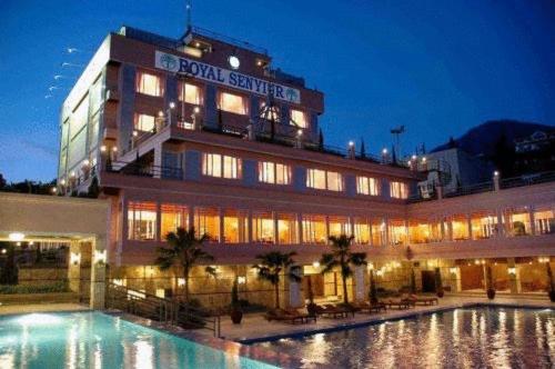 a hotel with a swimming pool in front of a building at Royal Senyiur Hotel in Prigen