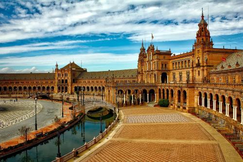 ein großes Gebäude mit einem Kanal davor in der Unterkunft Plaza de España. Dreams in Sevilla