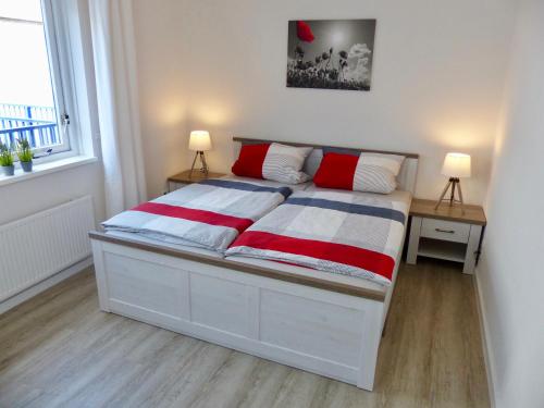a bedroom with a bed with red and white blankets at Petten Beach 17 in Petten