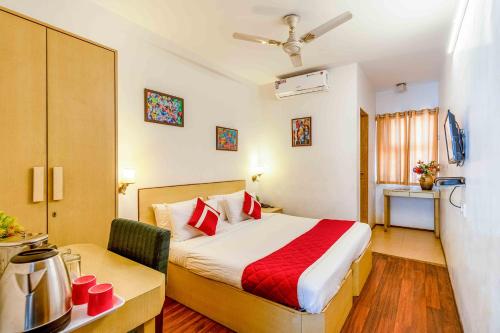 a hotel room with a bed and a desk and a room at Octave Adya Hotel in Bengaluru