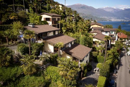 an aerial view of a house with palm trees and a road at Reka-Ferienanlage Brissago in Brissago