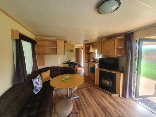 a living room with a couch and a table in a caravan at U Jędrusia in Polańczyk