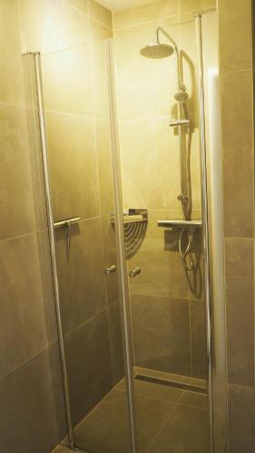 a shower with a glass door in a bathroom at Stad & Strand Appartement in Middelburg
