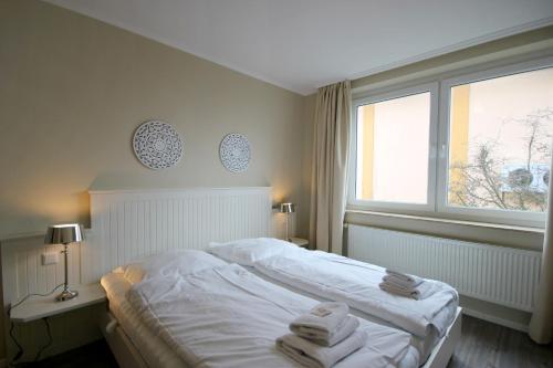 a bedroom with a white bed and a window at Villa Seeluft - by Rujana in Ostseebad Sellin