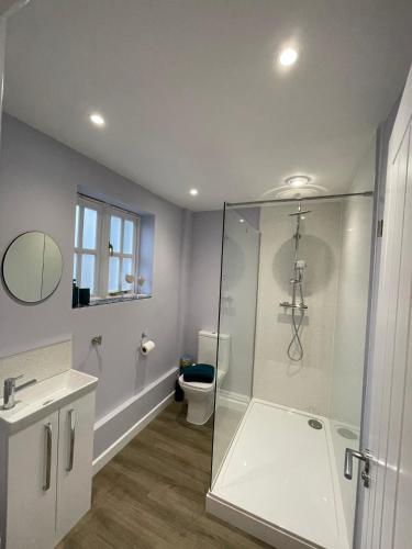 a bathroom with a glass shower and a toilet at Cromwell Lodge, Cromer, moments from the beach! in Cromer
