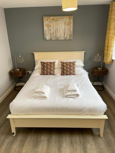 a bedroom with a white bed with towels on it at Cromwell Lodge, Cromer, moments from the beach! in Cromer