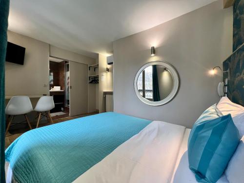 a bedroom with a large bed and a mirror at Hotel Nation Montmartre in Paris
