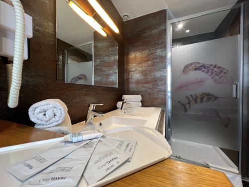 a bathroom with a sink and a mirror at Hotel Nation Montmartre in Paris