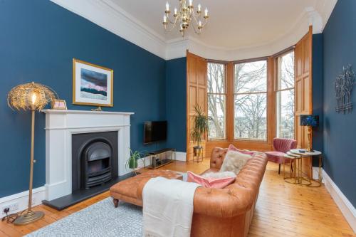 een woonkamer met een bank en een open haard bij South Learmonth Gardens Apartment in Edinburgh
