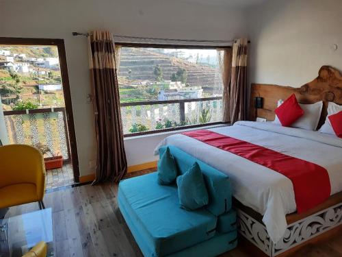 a bedroom with a large bed and a large window at Sunset Valley Holiday Inn in Ooty