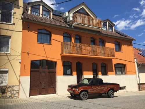 un camión marrón estacionado frente a un edificio en Vulkán Wellness Panzió, en Pécs