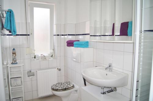 a white bathroom with a sink and a toilet at Scheitz 1 in Dahme