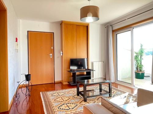 a living room with a couch and a tv and a table at Miguel Torga Diamond Penthouse in Coimbra