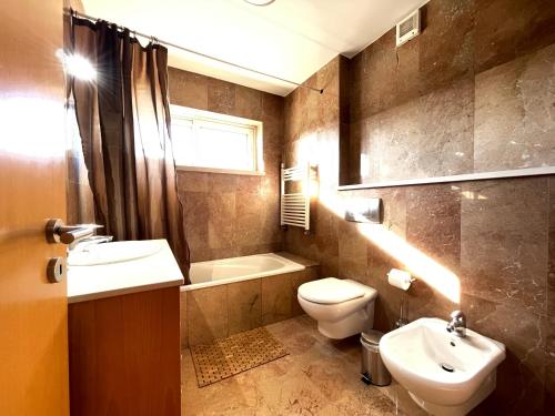 a bathroom with a sink and a toilet and a tub at Miguel Torga Diamond Penthouse in Coimbra