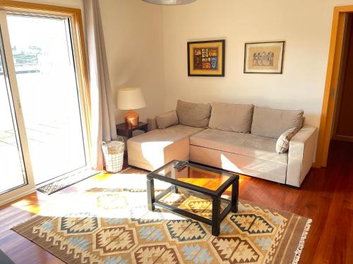 a living room with a couch and a coffee table at Miguel Torga Diamond Penthouse in Coimbra