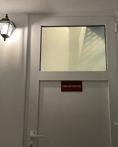 a glass door with a sign on it next to a lamp at Dream House Efi in Ravdhoúkha