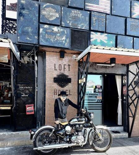 Una estatua de un hombre en una motocicleta frente a un edificio. en The Lofthouse Sansai, en Chiang Mai