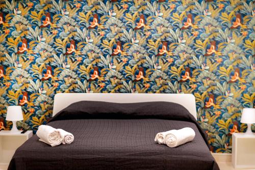 een slaapkamer met een bed met twee handdoeken erop bij LOGICO 56 in Bari