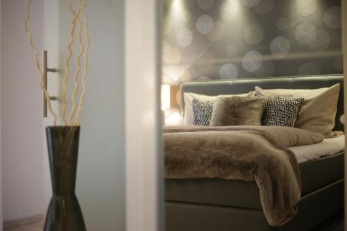 ein Schlafzimmer mit einem Bett mit Kissen darauf in der Unterkunft Appart-Hotel REB_ART in Deidesheim