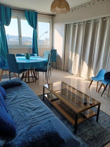 un salon avec un canapé, une table et des chaises dans l'établissement Bleu d'Arques Appartement lumineux et calme, à Dieppe