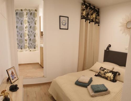 une chambre avec un lit avec deux oreillers dessus dans l'établissement Charmant studio avec coin nuit - vieille ville CLIMATISE, à Menton