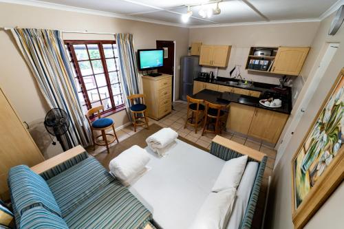 a living room with a couch and a kitchen at Gooderson Knysna Chalets in Knysna