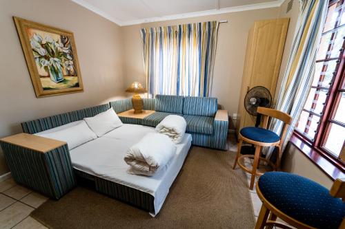 a living room with a couch and a chair at Gooderson Knysna Chalets in Knysna