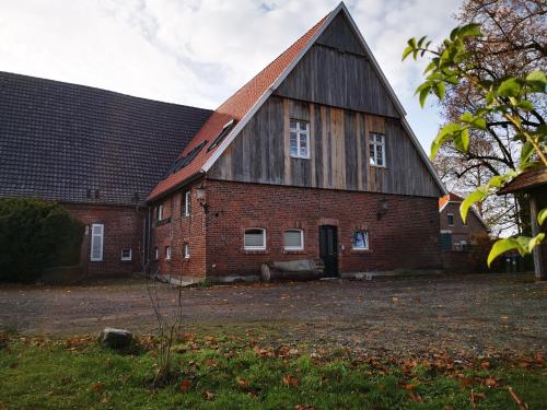 un antiguo granero de ladrillo rojo con techo negro en Ferienwohnung Fuchs en Münster