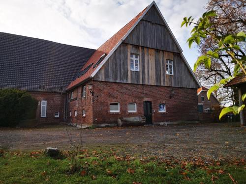 an old red brick barn with a black roof at Ferienwohnung Fuchs in Münster