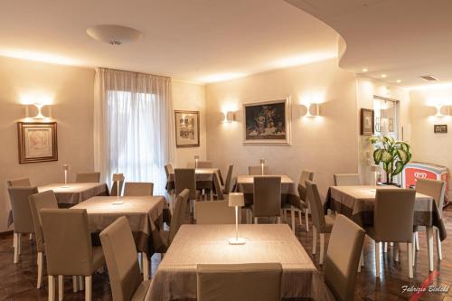 a restaurant with tables and chairs and a window at Albergo Bagner in Sirmione
