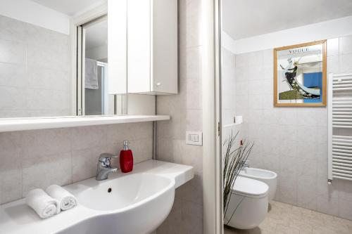 a white bathroom with a sink and a toilet at [NAVIGLI-DUOMO] Apartment with Netflix+Wifi in Milan