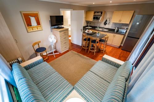 a living room with a couch and a kitchen at Gooderson Knysna Chalets in Knysna