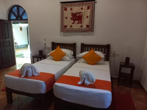 a bedroom with two beds with towels on them at Jim's Beach Villas in Hikkaduwa