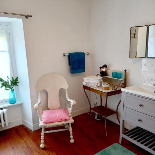 a bathroom with a chair and a desk with a sink at Chambres d'Hôtes Couleurs d'Elvine in Coutances