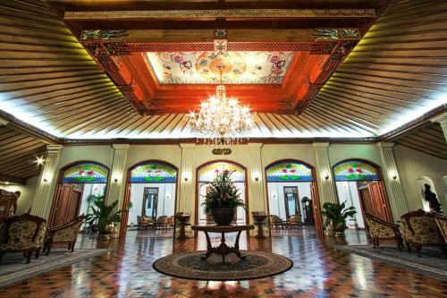 a large lobby with a chandelier and stained glass ceilings at Kusuma Sahid Prince Hotel Solo in Solo