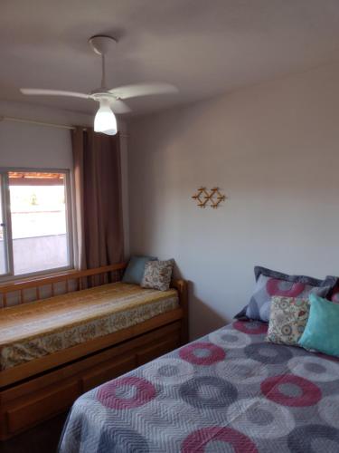 a bedroom with a bed and a window at Apartamento Cobertura in São Pedro da Aldeia