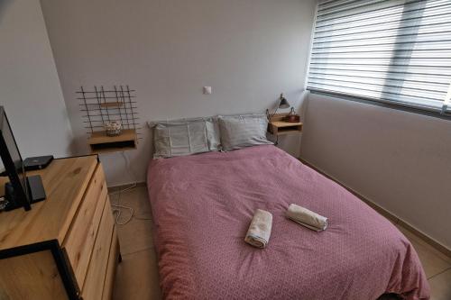 a bedroom with a bed with two towels on it at Folitsa a Lovely central House in Kos