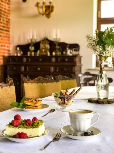 a table with plates of food and a cup of coffee at Dwór Gogolewo nad Wartą in Książ Wielkopolski