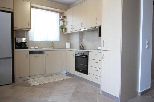 a kitchen with white cabinets and a window at Stellina's House in Káto Alissós