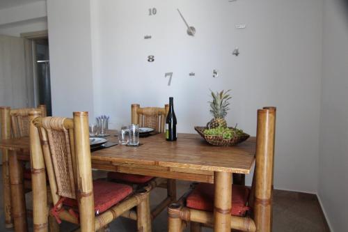 a wooden table with a bottle of wine and a bowl of pineapple at Stellina's House in Káto Alissós