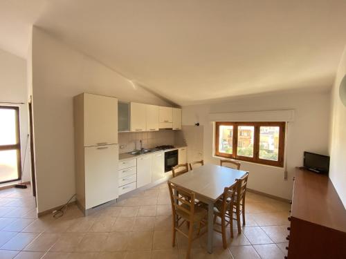 cocina con mesa y sillas en una habitación en Appartamenti dei Giardini, en Muravera