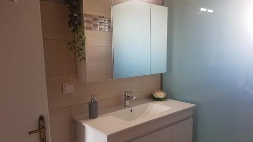 een badkamer met een witte wastafel en een spiegel bij Bei Kosta in Mesopótamon