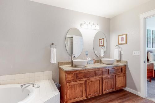 a bathroom with two sinks and a large mirror at Trees and Tees at Eagle Crest in Redmond