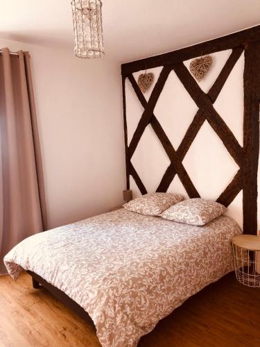 une chambre avec un lit avec une tête de lit en bois dans l'établissement Chez Jeanne - 2 personnes, à Colmar