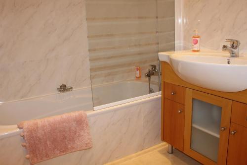 a bathroom with a sink and a bath tub next to a sink at Casa Jacqueline in Albufeira