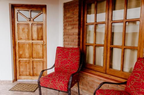 una sedia rossa seduta accanto a una porta di Hakuna Matata a Malargüe