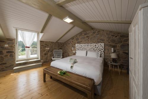 um quarto com uma cama grande num sótão em Cabaña de Nemiña (A casa de Anxo e Samu) em Muxía