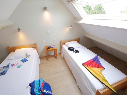 due letti in una stanza con un aquilone sul pavimento di ULVF Ty an Diaoul a Sarzeau