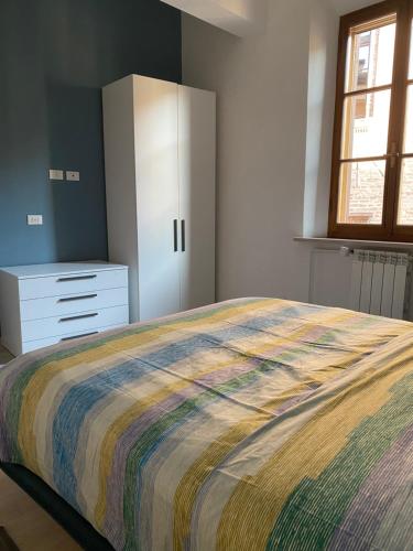a bedroom with a large bed and a dresser at CasaLonghi in Mantova
