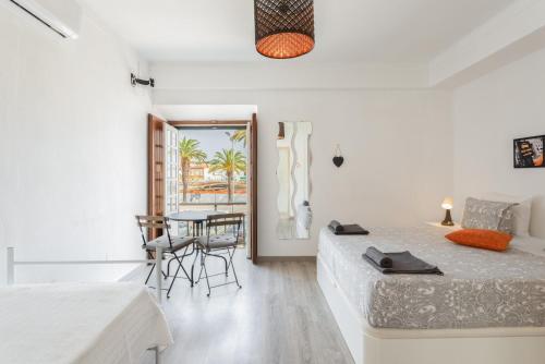 a white room with two beds and a table at Taah Billa Guest House in Tavira